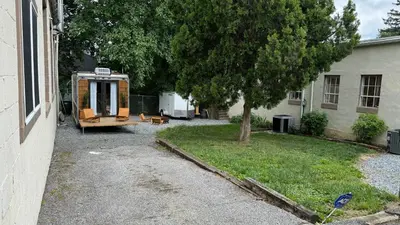 a tiny house sitting in a yard next to a house at City Hideaway, Off Grid Luxe in Lancaster