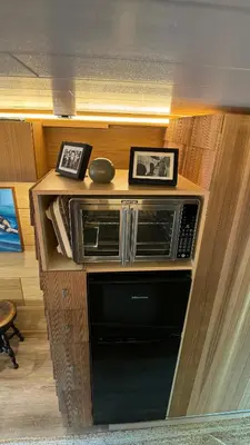 a microwave on a shelf with two pictures on it at City Hideaway, Off Grid Luxe in Lancaster