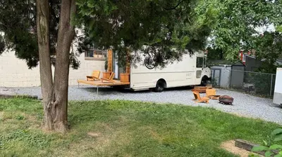 a rv parked in a yard next to a tree at City Hideaway, Off Grid Luxe in Lancaster