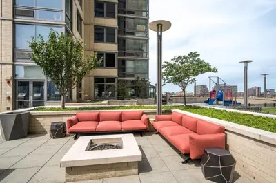 a patio with two red couches and a table at Global Luxury Suites Downtown Jersey City in Jersey City