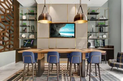 a dining room with a large wooden table and blue chairs at Global Luxury Suites Downtown Jersey City in Jersey City