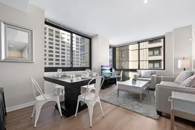 a living room with a table and chairs and a couch at Global Luxury Suites Downtown Jersey City in Jersey City