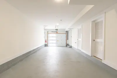 an empty hallway with white walls and white doors at Divine Essence in Newark