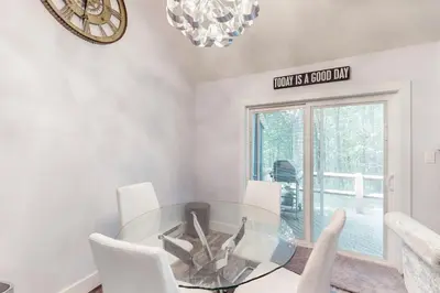 a dining room with a glass table and white chairs at The Best of Blakeslee in Blakeslee