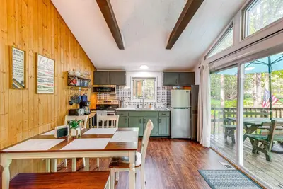 a kitchen with wooden walls and a table and chairs at Deck and Fire Pit Pet-Friendly Pocono Lake Abode! in Pocono Lake