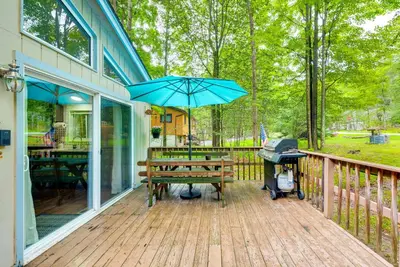 a grill and a picnic table with an umbrella on a deck at Deck and Fire Pit Pet-Friendly Pocono Lake Abode! in Pocono Lake