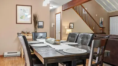 a dining room with a table and leather chairs at The Great Escape by AvantStay Game Room in Albrightsville