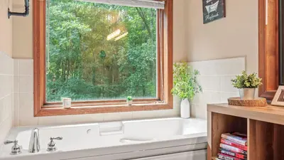 a bathroom with a bath tub and a window at The Great Escape by AvantStay Game Room in Albrightsville