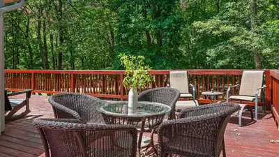 a patio with a table and chairs on a deck at The Great Escape by AvantStay Game Room in Albrightsville