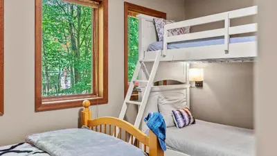 a bunk bed room with two bunk beds and a window at The Great Escape by AvantStay Game Room in Albrightsville