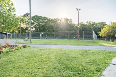 a park with a fence and a tennis court at Luxury Apt in Passaic