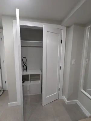 a white room with a door and a shelf at Luxury Apt in Passaic