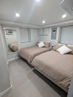 a bedroom with two beds and a mirror at Luxury Apt in Passaic
