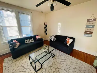 a living room with two black couches and a glass table at 3BR 1BA Near Train Station Monthly Deal in Elkins Park