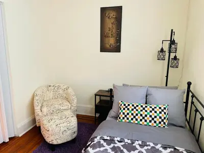 a bedroom with a chair next to a bed at 3BR 1BA Near Train Station Monthly Deal in Elkins Park