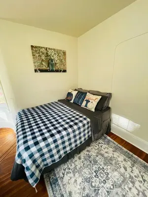 a small bedroom with a bed and a rug at 3BR 1BA Near Train Station Monthly Deal in Elkins Park