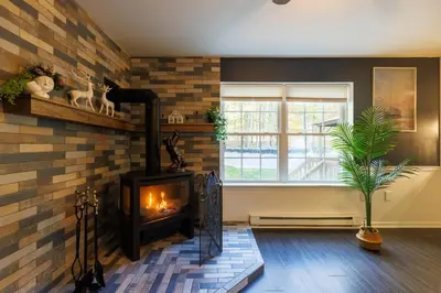 a fireplace in a living room with a brick wall at Mohawk-Kudil in Poconos ! Private Pool-Hot Tub-Lake Access-Game Room in Albrightsville