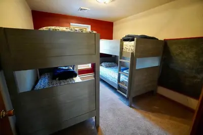 two bunk beds in a small room with twounks at Big Blue Lake House complete with Game Room in Long Pond