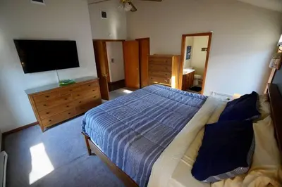a bedroom with a bed and a flat screen tv at Big Blue Lake House complete with Game Room in Long Pond