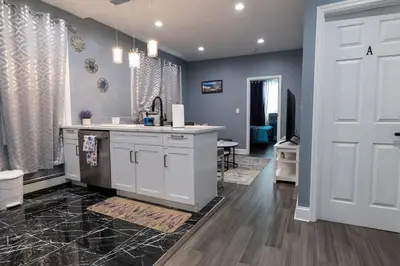 a kitchen with a white counter and a door at New Apartment Liberty State Park Jersey City NJ Airport Train Manhattan NYC in Jersey City