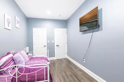 a room with a bed and a tv on a wall at New Apartment Liberty State Park Jersey City NJ Airport Train Manhattan NYC in Jersey City