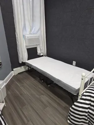 a small bed in a room with a window at New Apartment Liberty State Park Jersey City NJ Airport Train Manhattan NYC in Jersey City