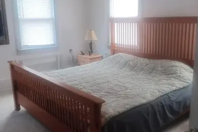 a bedroom with a large bed with a wooden frame at Old farmhouse with Hot tub in the Finger Lakes in Horseheads