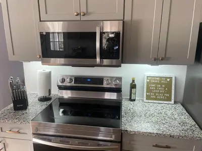 a kitchen with a stove and a microwave at Old farmhouse with Hot tub in the Finger Lakes in Horseheads