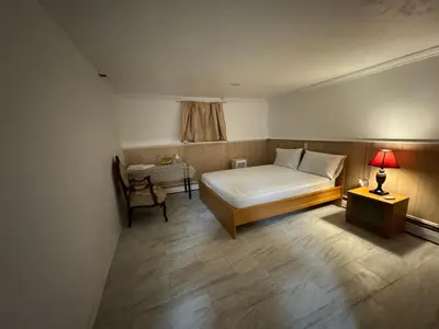 a bedroom with a bed and a table with a lamp at The White Pearl in Metuchen