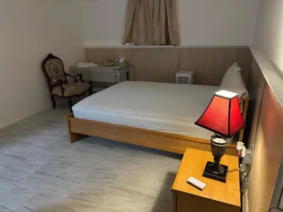 a bedroom with a bed and a lamp on a table at The White Pearl in Metuchen