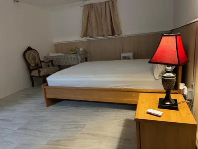 a bedroom with a bed and a lamp on a table at The White Pearl in Metuchen
