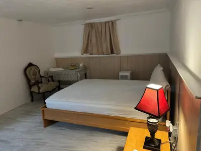 a bedroom with a bed and a table with a lamp at The White Pearl in Metuchen