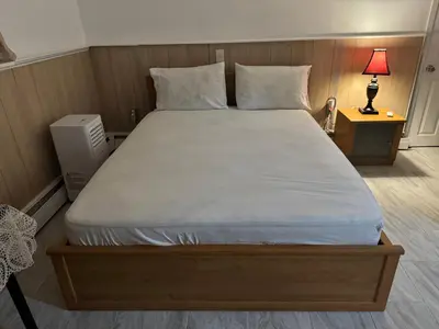 a bedroom with a large bed with white sheets and pillows at The White Pearl in Metuchen