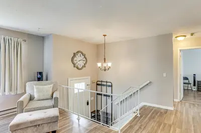 a living room with a staircase and a chair at 5 Mi to Downtown Harrisburg - Family Home! in Harrisburg