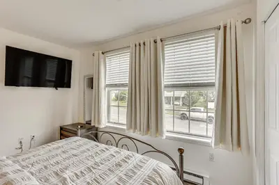a bedroom with a bed and two windows at 5 Mi to Downtown Harrisburg - Family Home! in Harrisburg