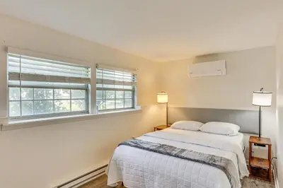 a bedroom with a bed and two windows at 5 Mi to Downtown Harrisburg - Family Home! in Harrisburg