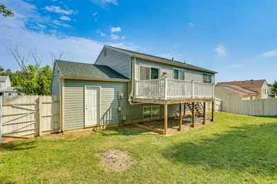 a green house with a deck and a fence at 5 Mi to Downtown Harrisburg - Family Home! in Harrisburg