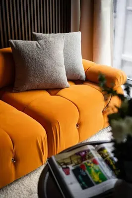an orange couch with pillows in a living room at Luxury Full Floor Chelsea Apt St 7 in New York