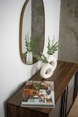 a table with a mirror and vases and a magazine at Luxury Full Floor Chelsea Apt St 7 in New York
