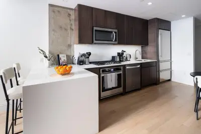 a kitchen with wooden cabinets and a counter top at Luxury Full Floor Chelsea Apt St 7 in New York