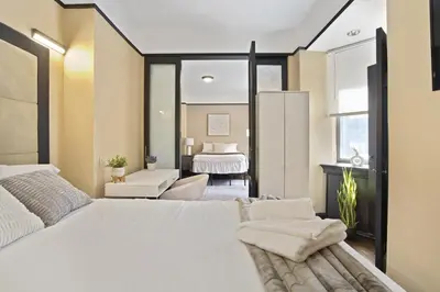 a bedroom with a large white bed and a living room at Mansfield in New York
