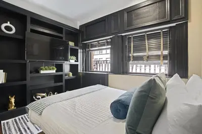 a bedroom with black cabinets and a bed with blue pillows at Mansfield in New York