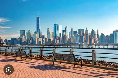 two benches on a pier with a view of a city at Apart Studio West NY 12Mints From NYCity Times Square in West New York