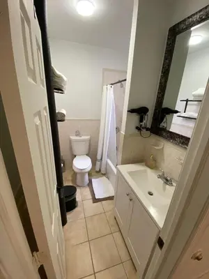 a bathroom with a toilet and a sink and a mirror at Apart Studio West NY 12Mints From NYCity Times Square in West New York