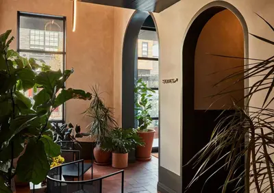a hallway with potted plants and a door at Archway Hotel Residence in Philadelphia