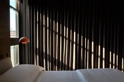 a bedroom with a bed and a large window at Archway Hotel Residence in Philadelphia