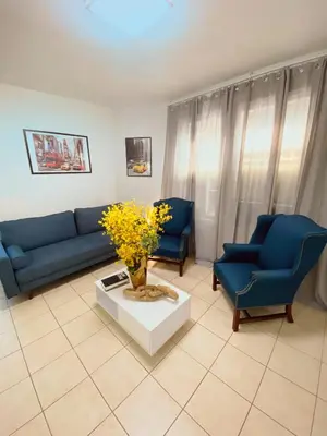 a living room with blue couches and a table and flowers at Private Room A-KING BED-12Mints NYCity Times Square in West New York