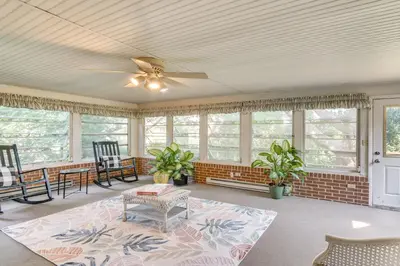 a living room with a ceiling fan and windows at Movie Room and Home Gym Sinking Spring Home! in Sinking Spring