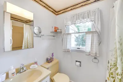 a bathroom with a sink and a toilet and a window at Movie Room and Home Gym Sinking Spring Home! in Sinking Spring