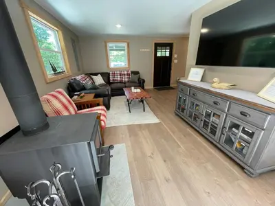 a living room with a large flat screen tv at Private Cottage with Hot Tub in the Woods in Thompson
